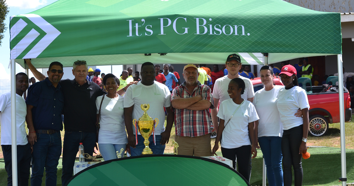 PG bison members under gazebo with a trophy
